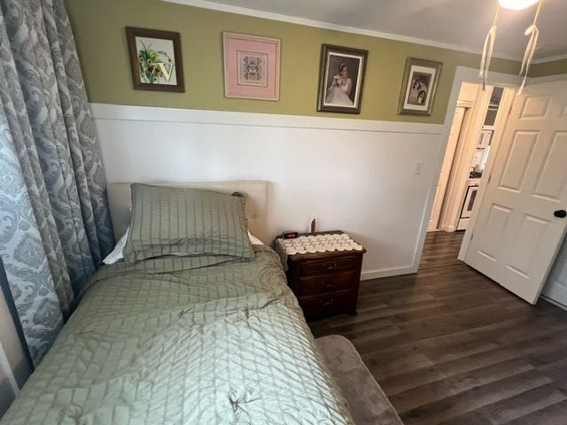 bedroom with dark hardwood / wood-style flooring and ornamental molding