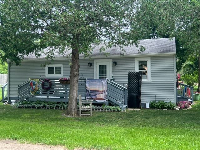 rear view of house featuring a yard and a wooden deck