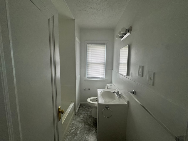 bathroom featuring vanity, a textured ceiling, and toilet