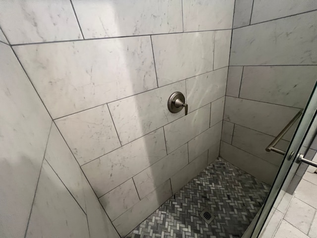 interior details with a tile shower