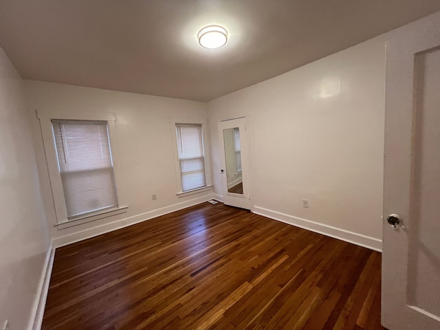 spare room with dark wood-type flooring