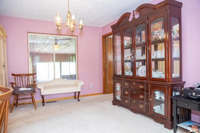 sitting room featuring light colored carpet and an inviting chandelier