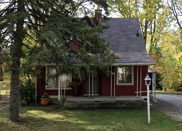 18293 Codding St, Detroit, MI 48219 - view of front of property featuring covered porch, a chimney, a front yard, and a shingled roof