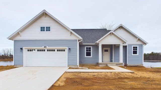 view of front of property featuring driveway and roof with shingles