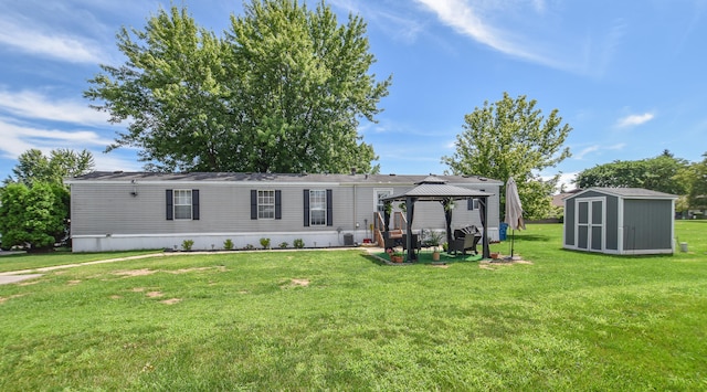 exterior space featuring a gazebo, a front yard, and a storage shed