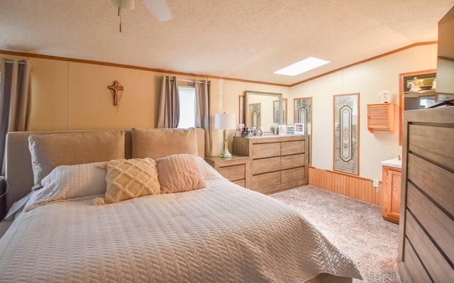 bedroom with ceiling fan, crown molding, light colored carpet, a textured ceiling, and vaulted ceiling with skylight