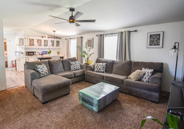 carpeted living room with vaulted ceiling and ceiling fan