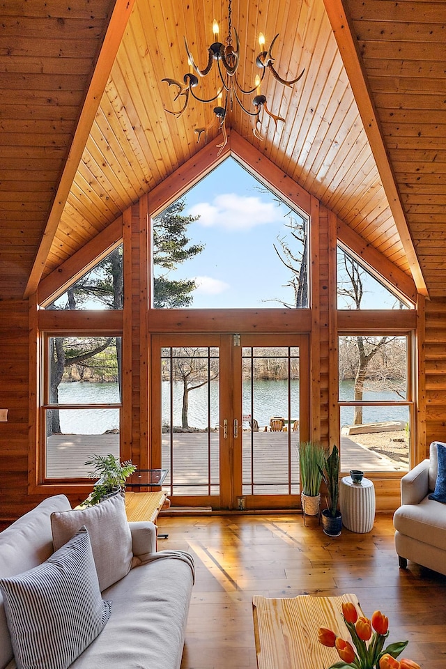 living room featuring wood ceiling, hardwood / wood-style floors, a water view, and a healthy amount of sunlight