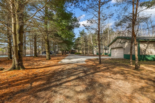 view of yard featuring a garage, an outdoor structure, and a water view