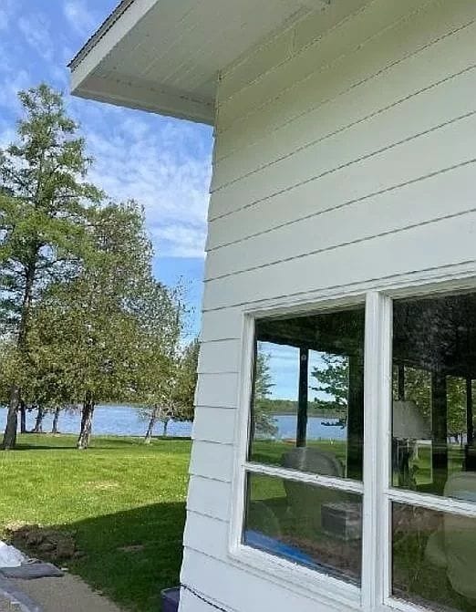 view of home's exterior featuring a lawn and a water view