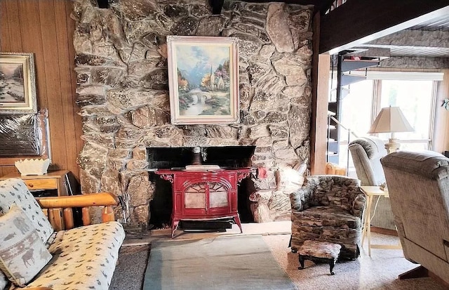 living area with a wood stove and wood walls