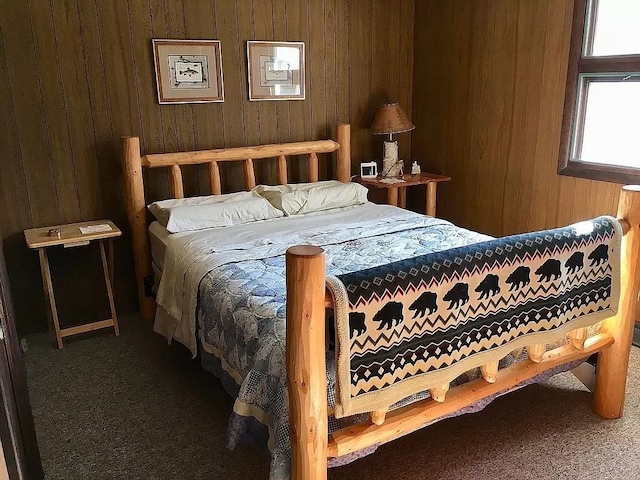 carpeted bedroom with wooden walls