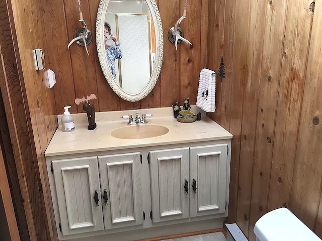 bathroom with vanity and wooden walls