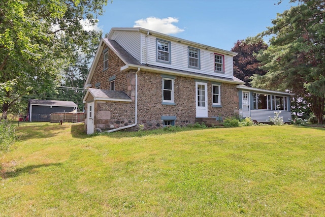 view of front of property featuring a sunroom and a front lawn