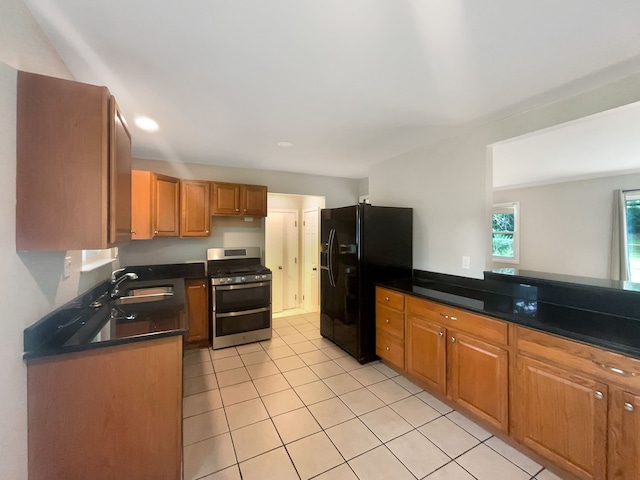 kitchen with gas stove, light tile patterned floors, sink, and black refrigerator with ice dispenser