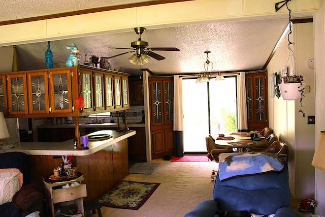 2802 Coulter Creek Trl, Central Lake, MI 49622 - kitchen with hanging light fixtures, kitchen peninsula, a textured ceiling, light carpet, and ceiling fan with notable chandelier