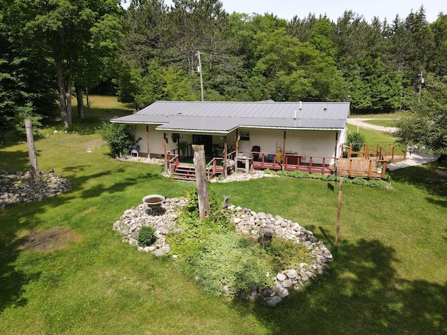 2802 Coulter Creek Trl, Central Lake, MI 49622 - rear view of property featuring a yard, a deck, and an outdoor fire pit