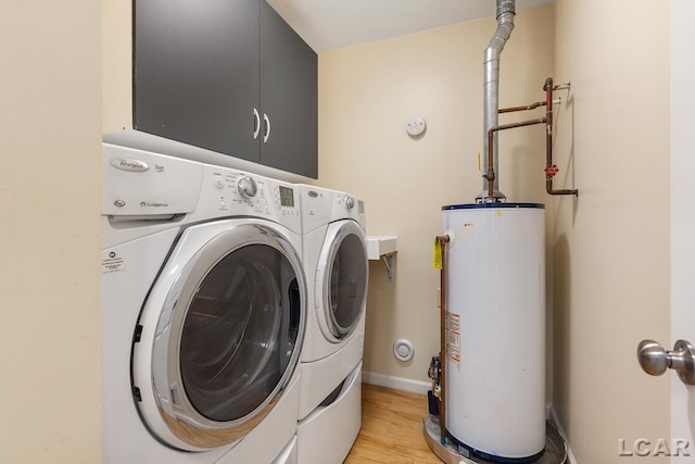 clothes washing area with separate washer and dryer, gas water heater, and light hardwood / wood-style floors