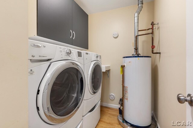 12171 Grandview Dr, Jerome, MI 49249 - washroom with water heater, separate washer and dryer, light wood-style flooring, and baseboards