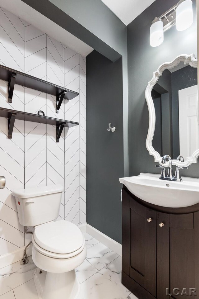 12171 Grandview Dr, Jerome, MI 49249 - half bath with marble look tile flooring, toilet, vanity, and baseboards