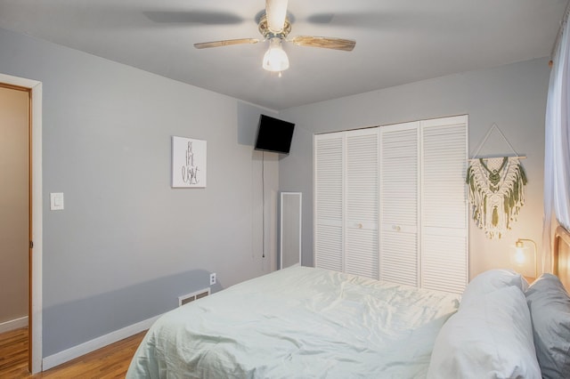 bedroom with light wood-type flooring, a closet, and ceiling fan