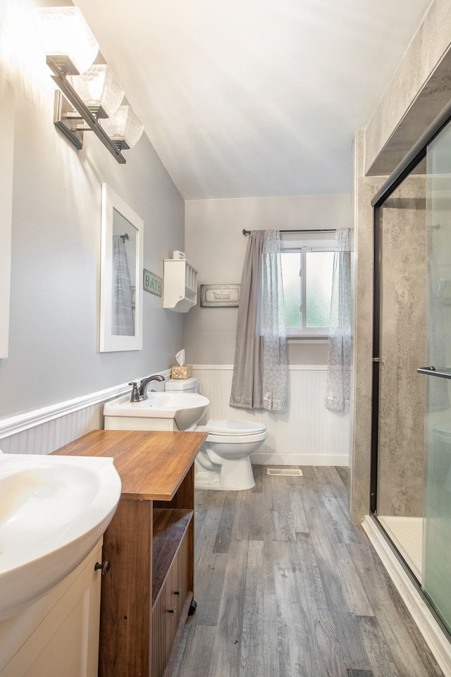 bathroom with walk in shower, vanity, hardwood / wood-style flooring, toilet, and wood walls