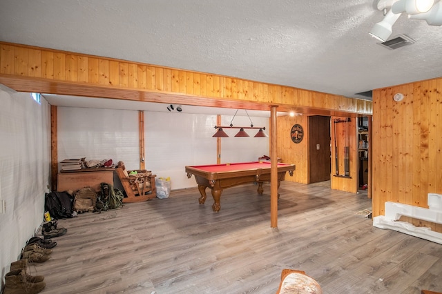 recreation room with hardwood / wood-style flooring, wooden walls, a textured ceiling, and billiards