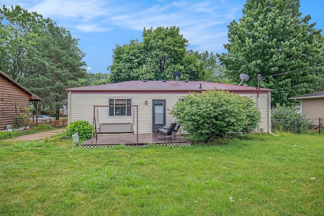 rear view of property with a yard and a wooden deck