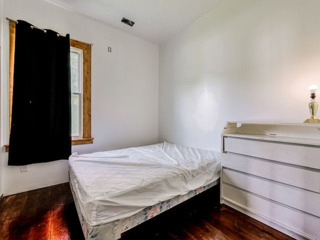 bedroom with dark wood-type flooring