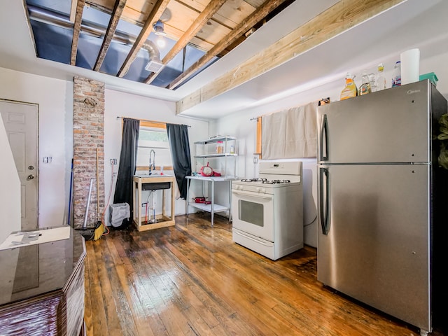 kitchen featuring beamed ceiling, stainless steel fridge, dark hardwood / wood-style flooring, and gas range gas stove