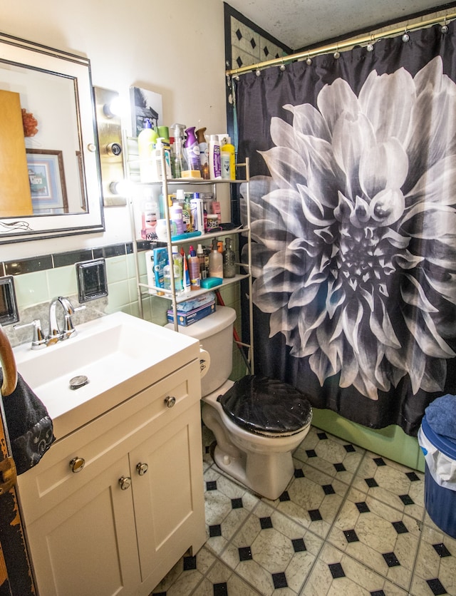 bathroom with vanity, tasteful backsplash, and toilet