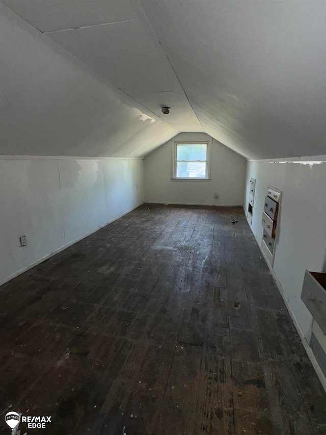 additional living space with dark hardwood / wood-style flooring and vaulted ceiling