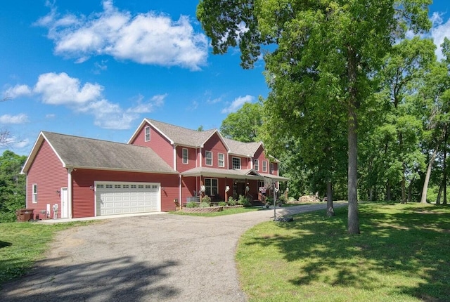 colonial home with a porch, a garage, and a front lawn