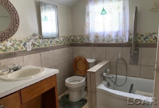 bathroom featuring a washtub, toilet, tile walls, and vanity