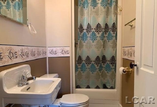 full bathroom with toilet, shower / bath combo with shower curtain, and sink