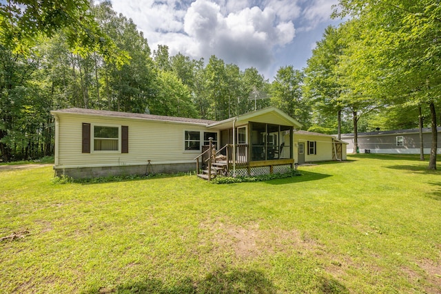 rear view of property featuring a lawn and a sunroom