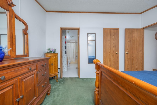 hall with dark carpet, crown molding, and a textured ceiling