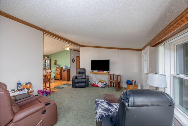 carpeted living room featuring vaulted ceiling, ceiling fan, and crown molding