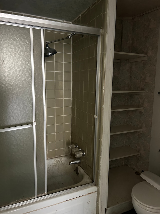 bathroom with toilet and enclosed tub / shower combo