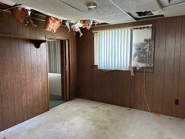 carpeted spare room with wood walls