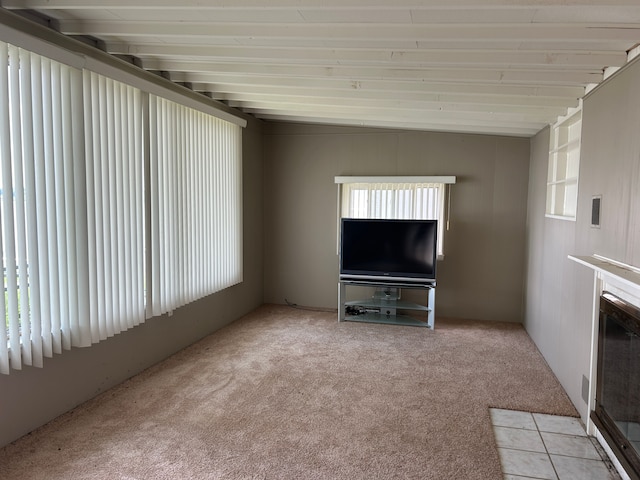 unfurnished living room with light carpet and lofted ceiling with beams