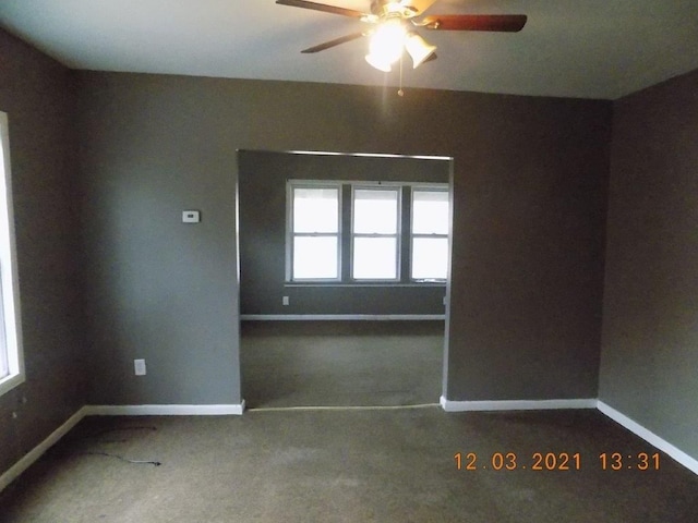 spare room with ceiling fan and carpet