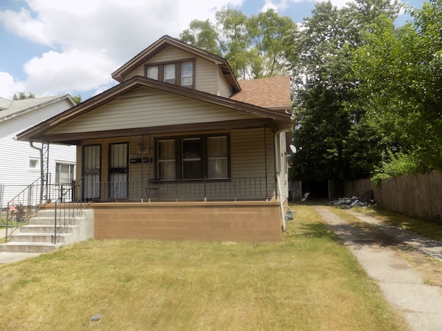 bungalow with a porch and a front lawn