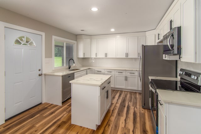 kitchen with white cabinets, a center island, dark hardwood / wood-style flooring, and stainless steel appliances