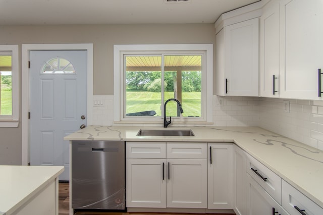 kitchen featuring light stone countertops, white cabinetry, sink, and stainless steel dishwasher