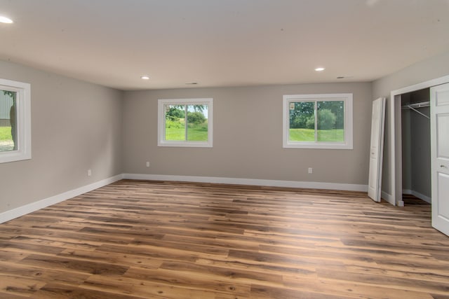 unfurnished bedroom featuring hardwood / wood-style flooring and multiple windows