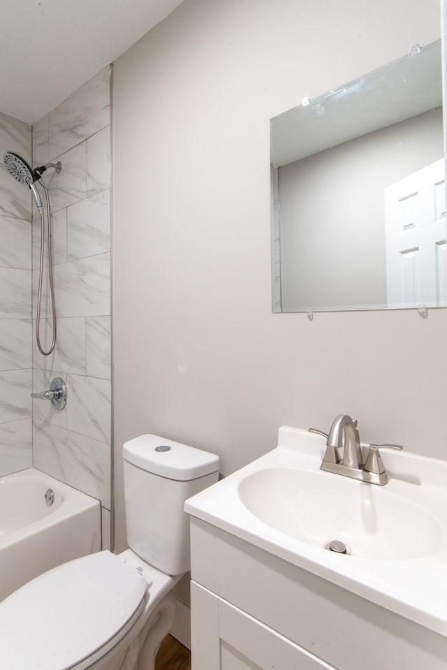 full bathroom with toilet, vanity, and tiled shower / bath