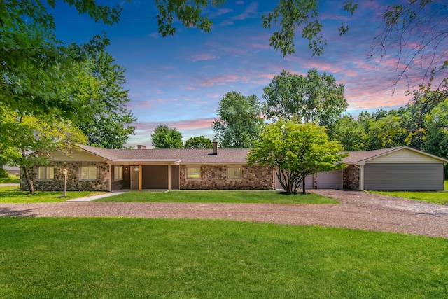 ranch-style house featuring a garage and a lawn