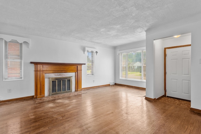 unfurnished living room featuring hardwood / wood-style floors and a textured ceiling