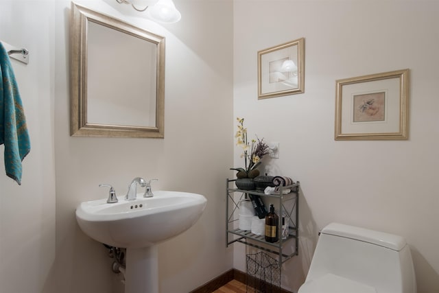 bathroom with hardwood / wood-style floors, toilet, and sink